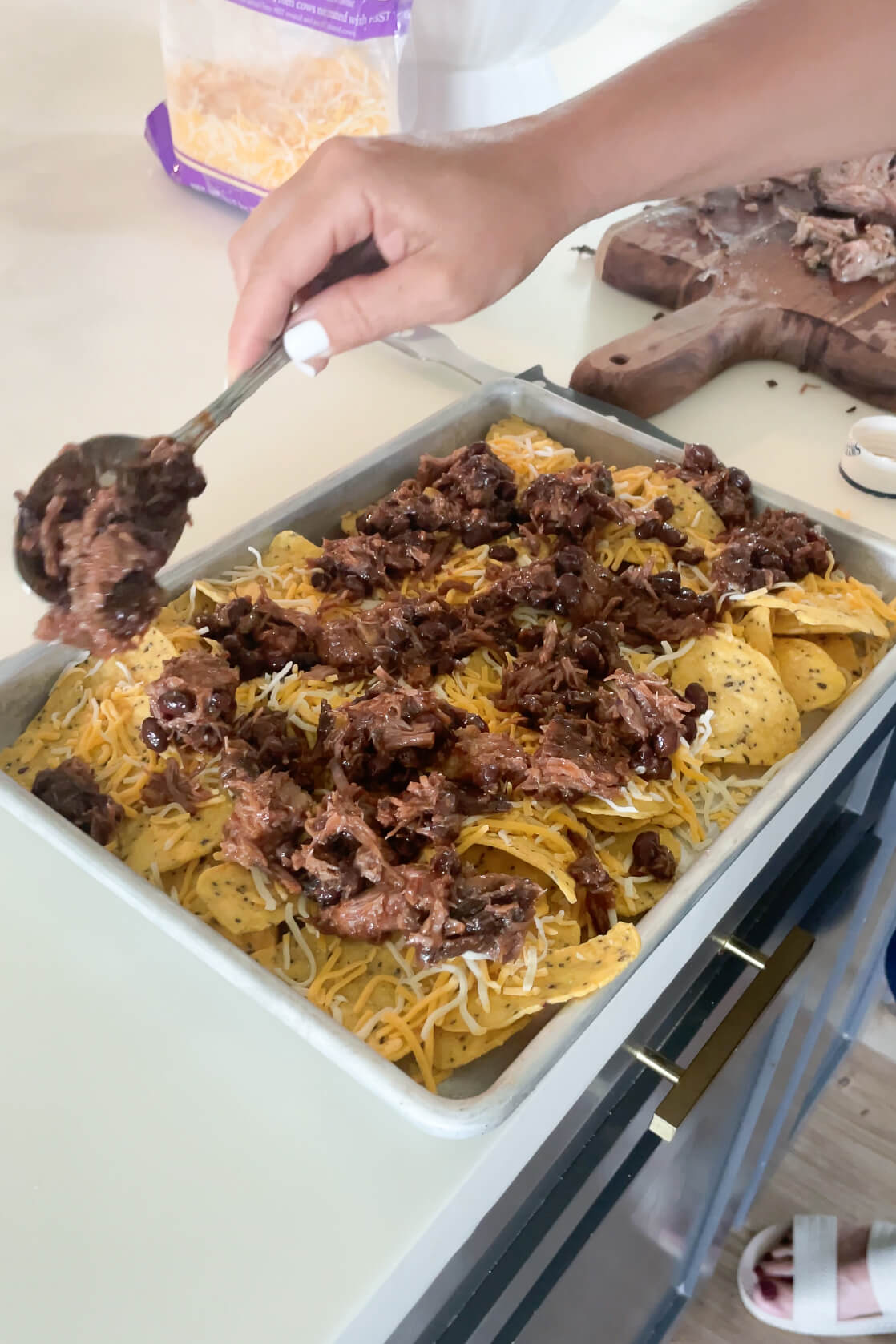 Adding smoked brisket to smoked brisket nachos.